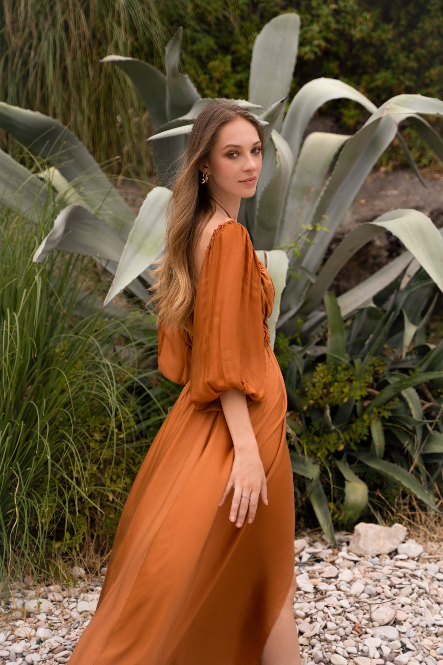 A terracotta maxi dress, with puff sleeves and shirred bust.