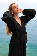 A black linen maxi dress, with long puff sleeves, ruffles and open back with ties.