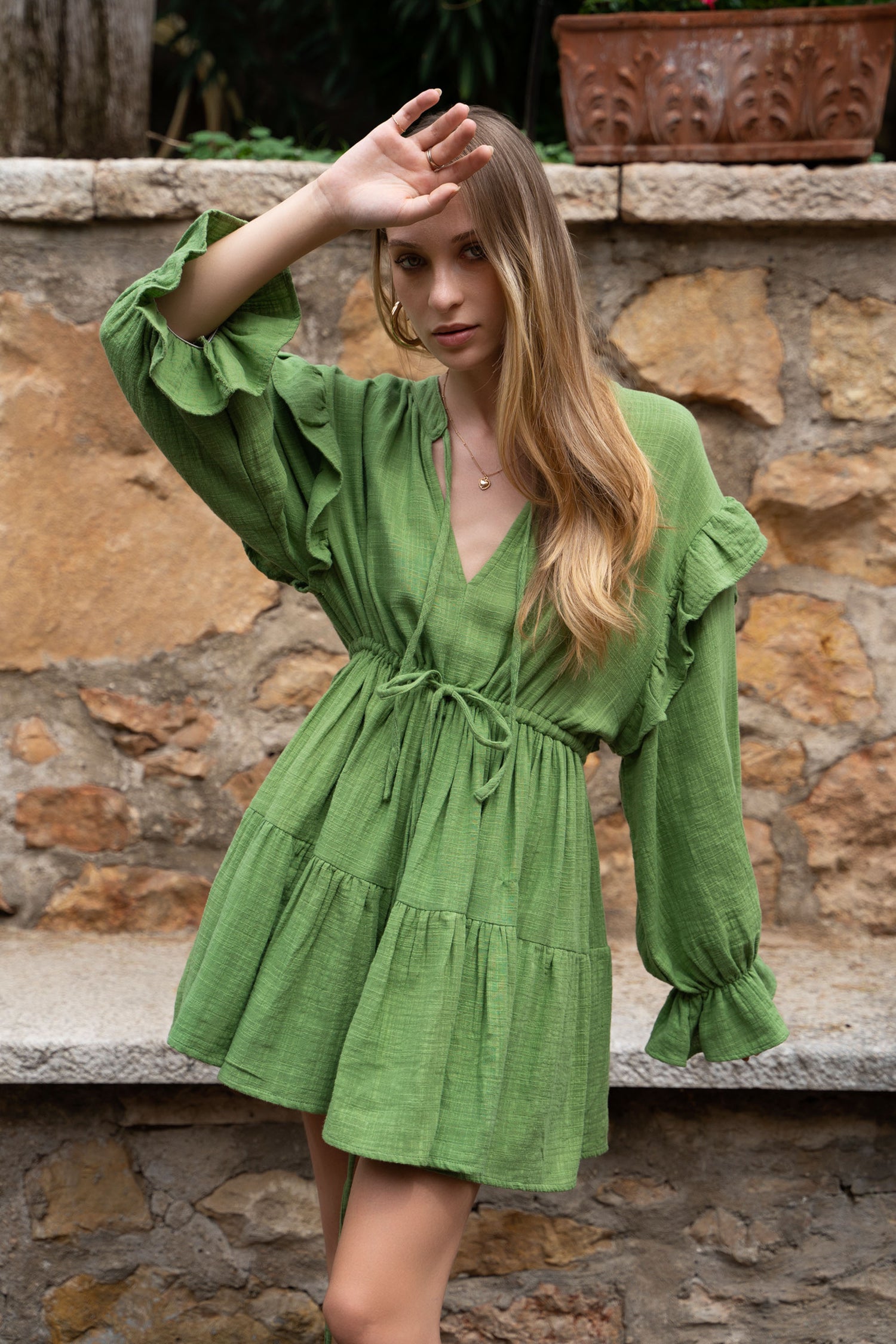 A green cotton Fiamma Studio dress, with long puff sleeves and tiered skirt.