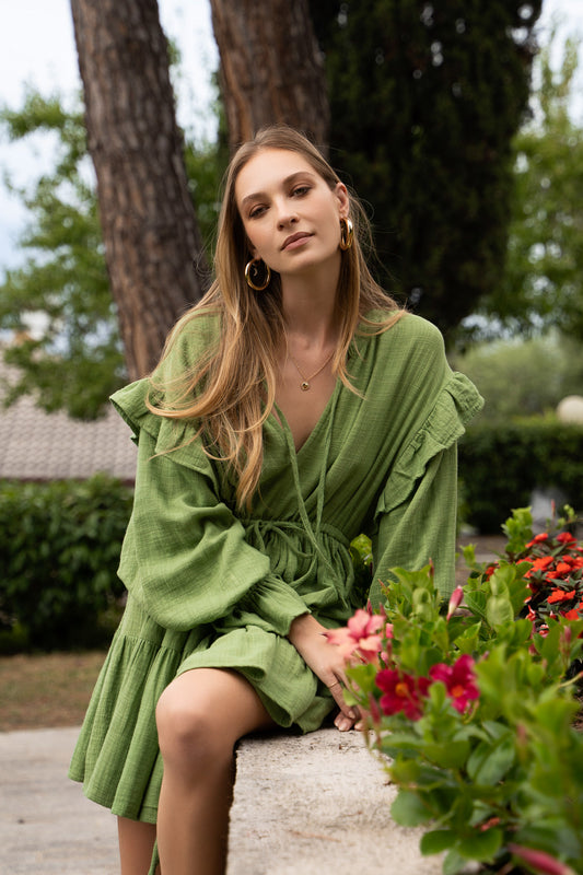 A green cotton Fiamma Studio dress, with long puff sleeves and wrist frills cuffs.