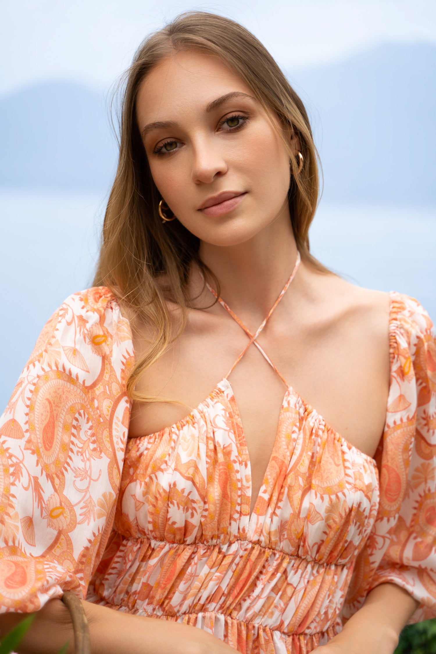 Orange printed maxi dress with puff sleeves and shirred bodice.