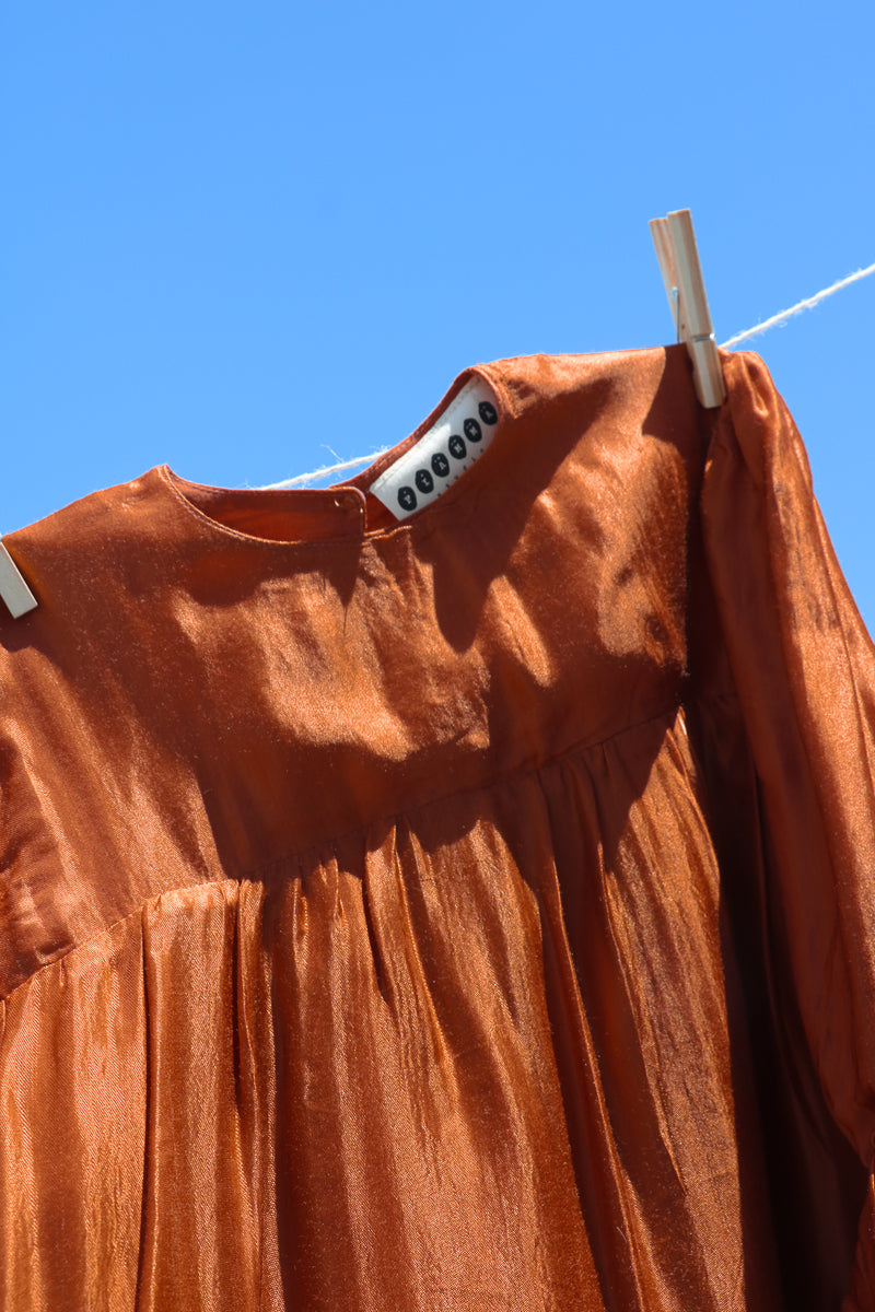 Terracotta dress for girls, with long sleeves and tiered skirt.