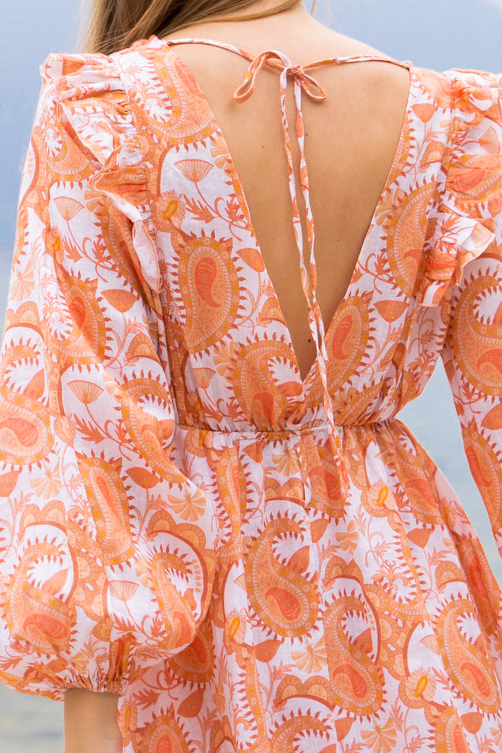 Floral paisley printed orange linen maxi dress, with long puff sleeves, a-line skirt, ruffles and open back with ties.