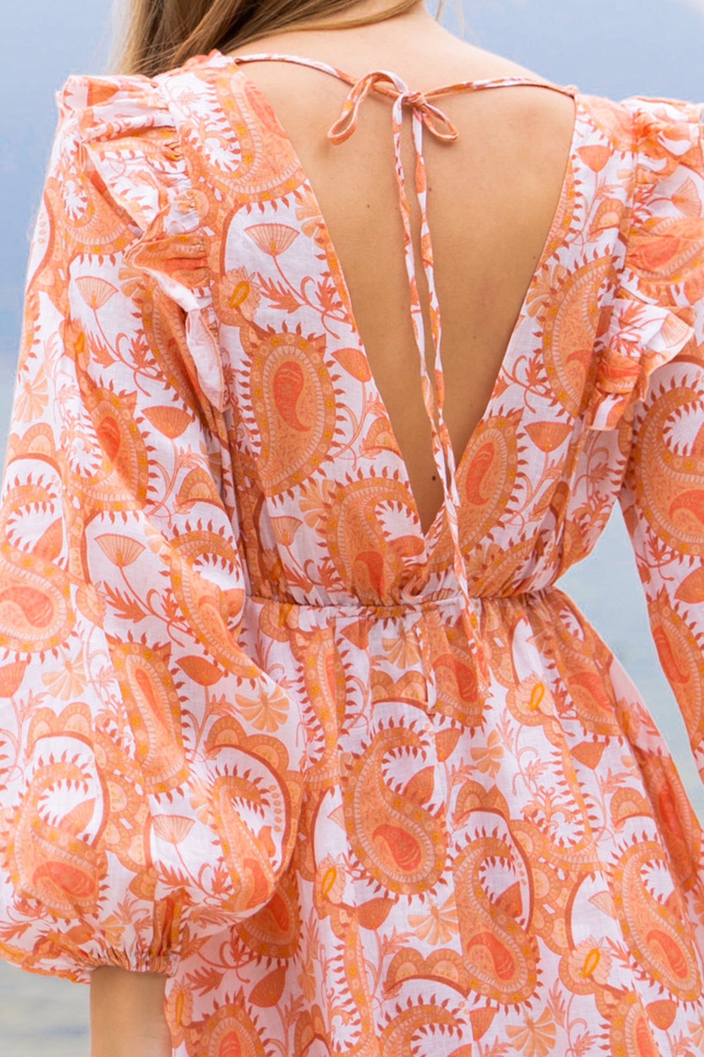 Floral paisley printed orange linen maxi dress, with long puff sleeves, a-line skirt, ruffles and open back with ties.