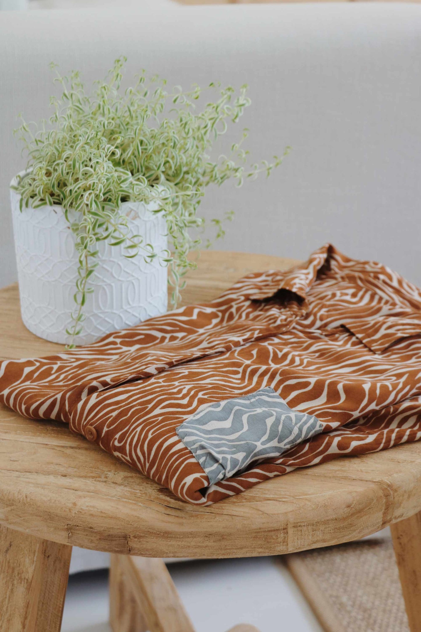 Sand zebra print set with oversize shirt on a wooden stool.