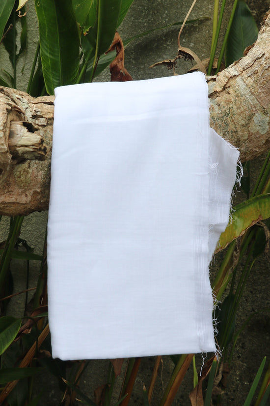 Photograph of a piece of white linen fabric placed on a tree.