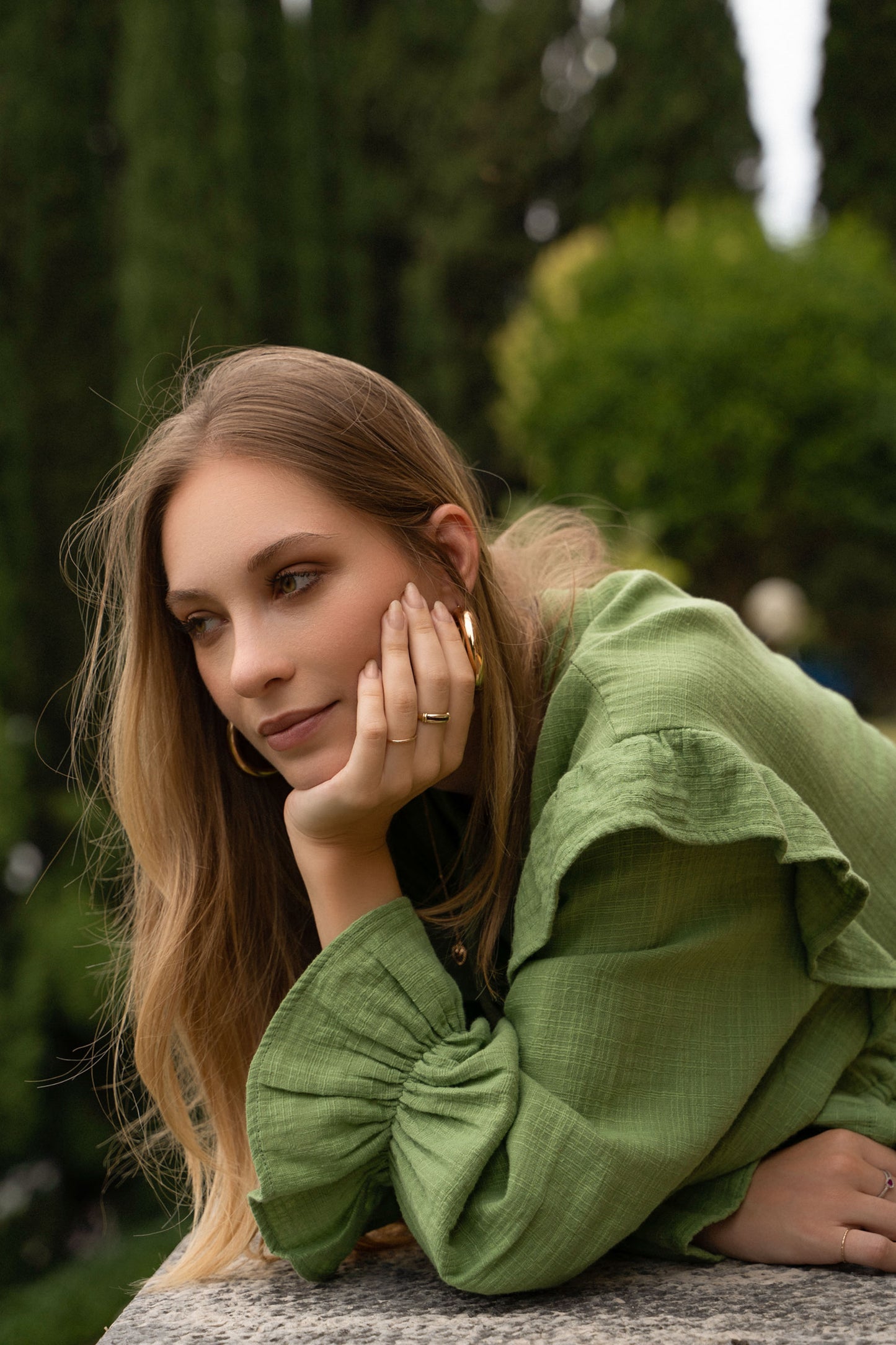 A green cotton Fiamma Studio dress, with long puff sleeves, waist ties and tiered skirt.