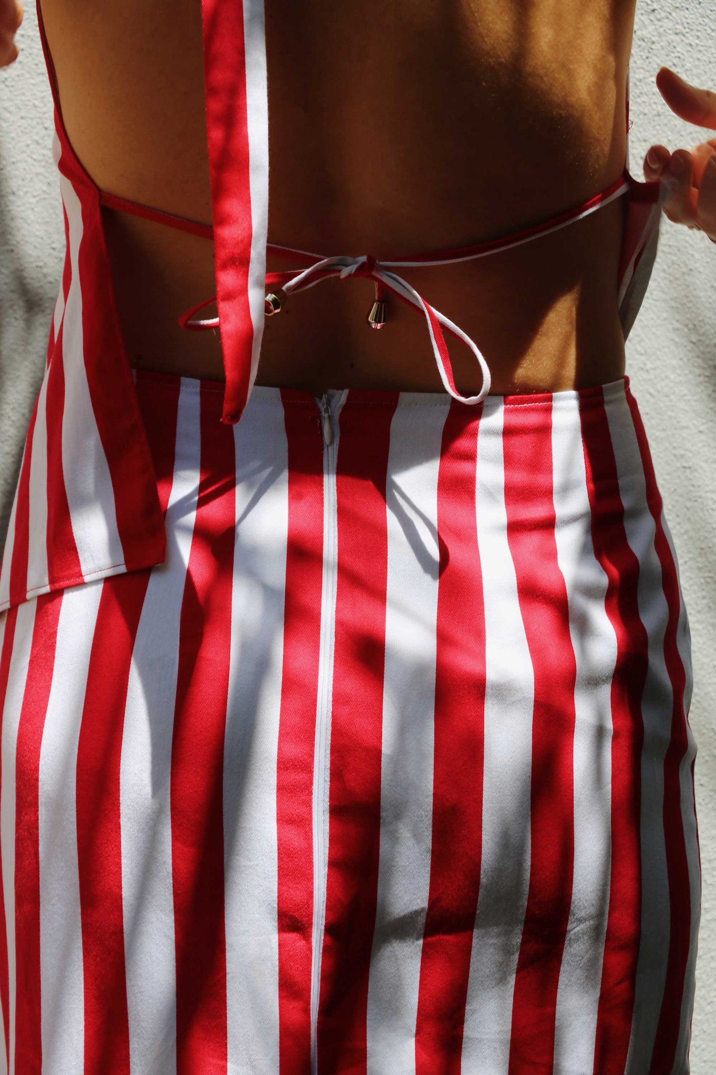 Striped set with pencil skirt, asymmetrical top, red and white stripes and open back.