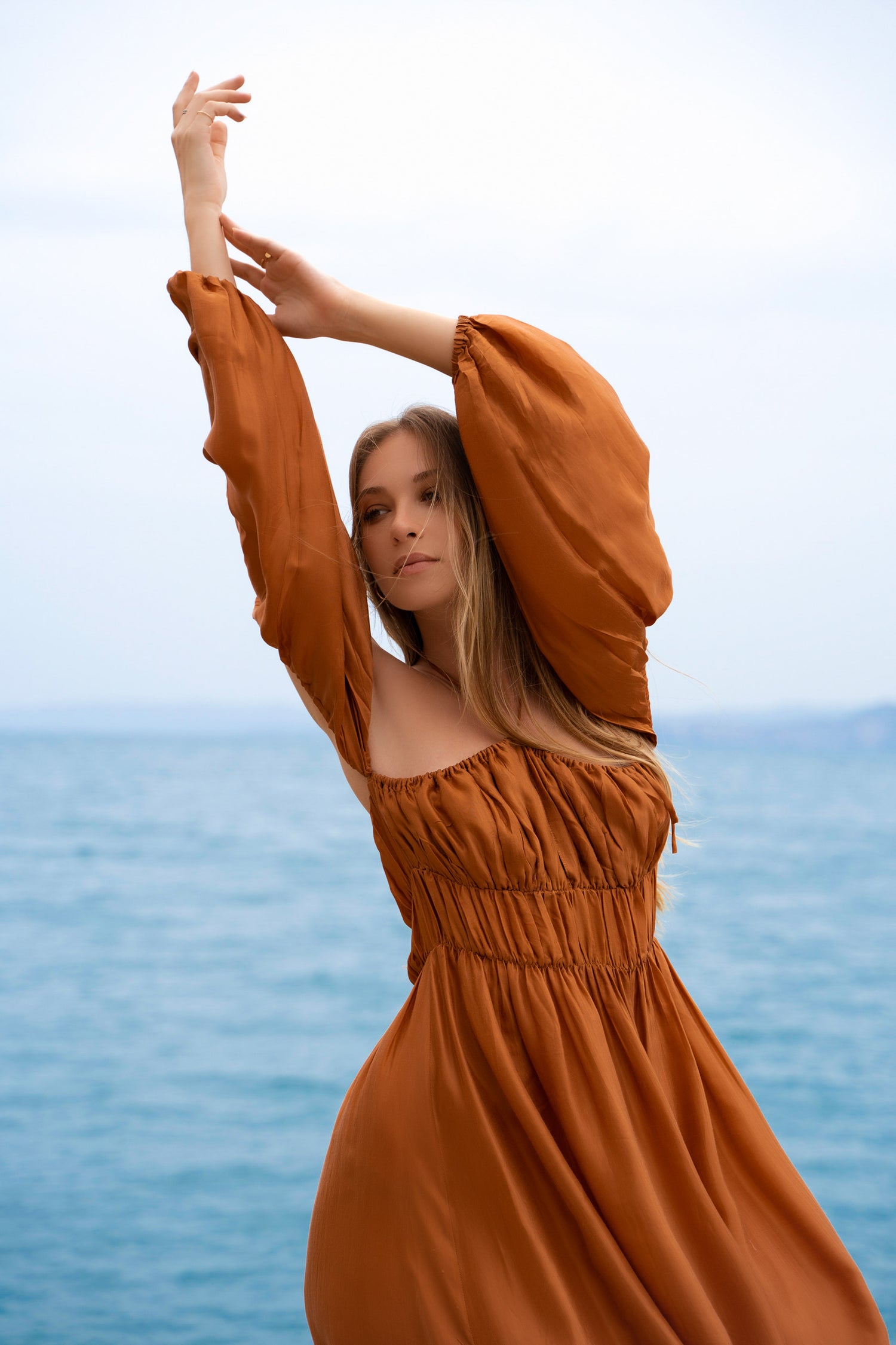 A terracotta maxi dress, with puff sleeves and shirred bust.