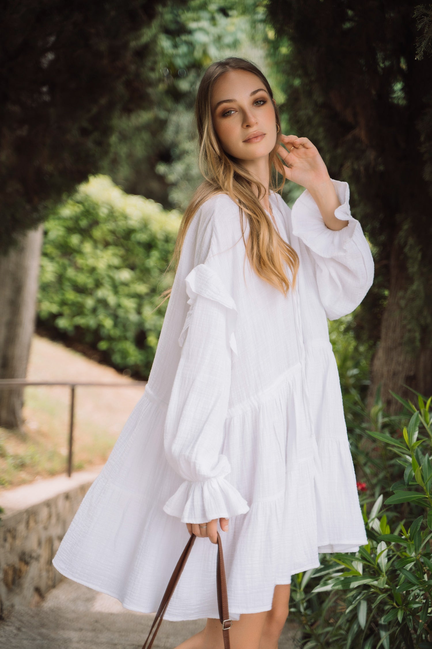 White summer dress with ruffled sleeves and tiered skirt.