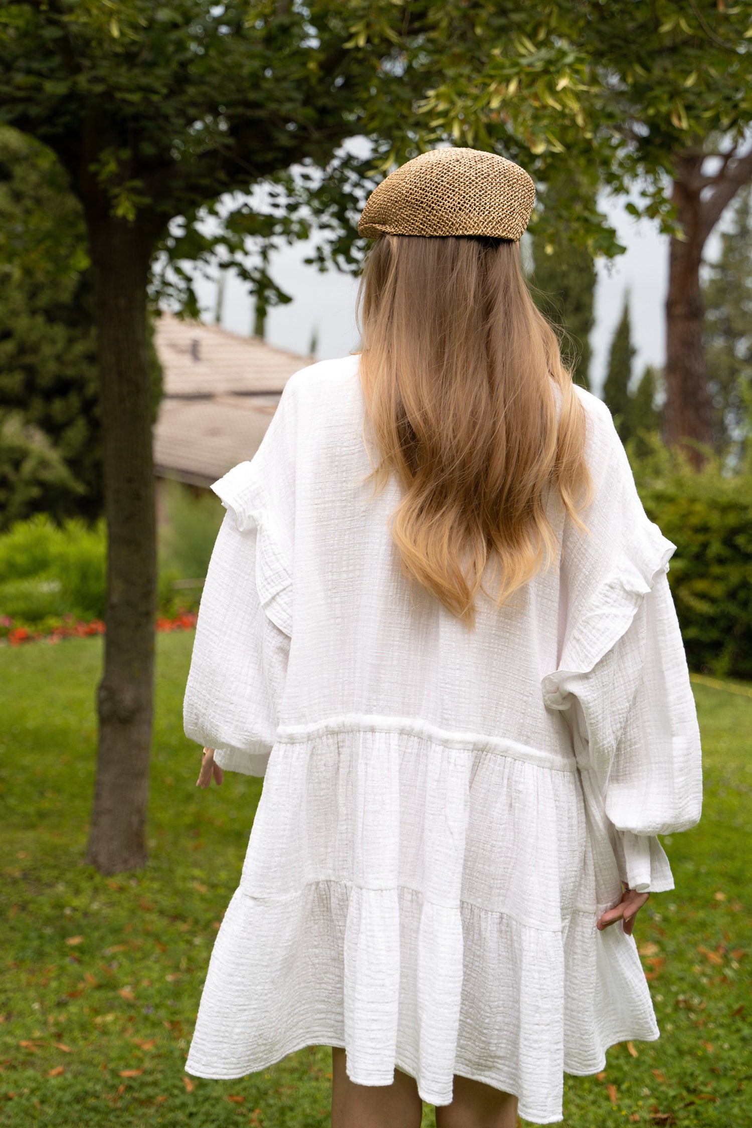 A white cotton dress with long puff sleeves with drawstrings at waistline.