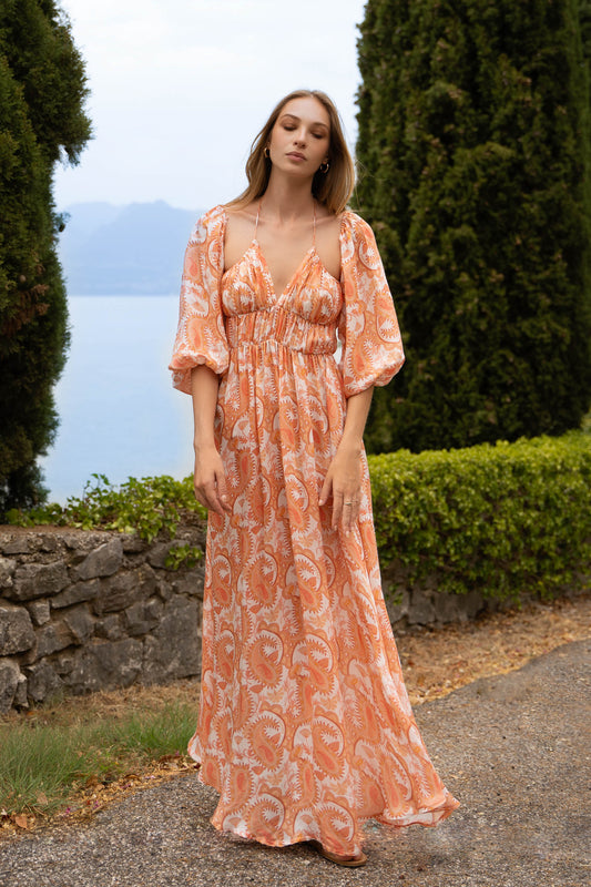 Full figure of orange print paisleys maxi Fiamma Studio dress, with puff sleeves, a-line skirt, shirred bust and thin straps neckline.