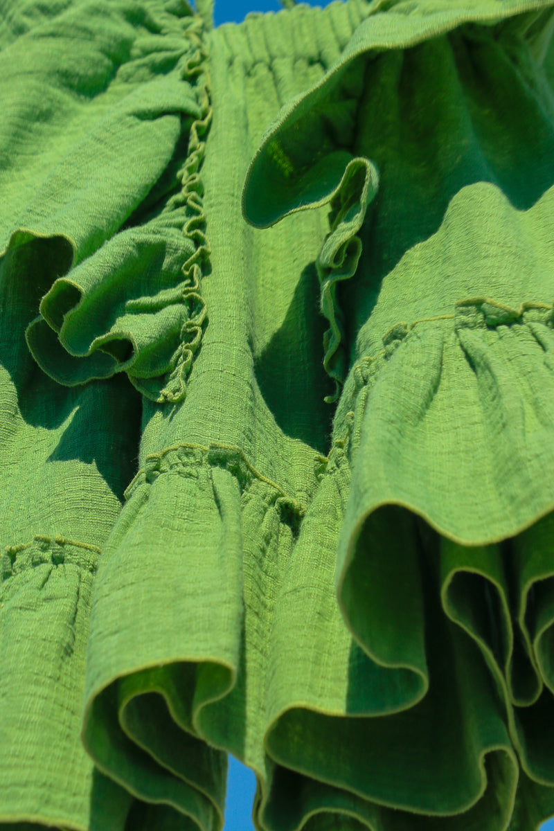 Close-up of green flowy dress for girls, doble cotton gauze sustainable fabric.