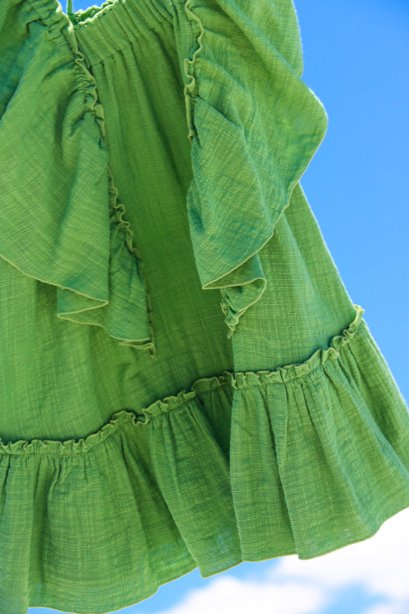 Close-up green cotton dress for toddlers, doble cotton gauze sustainable fabric.