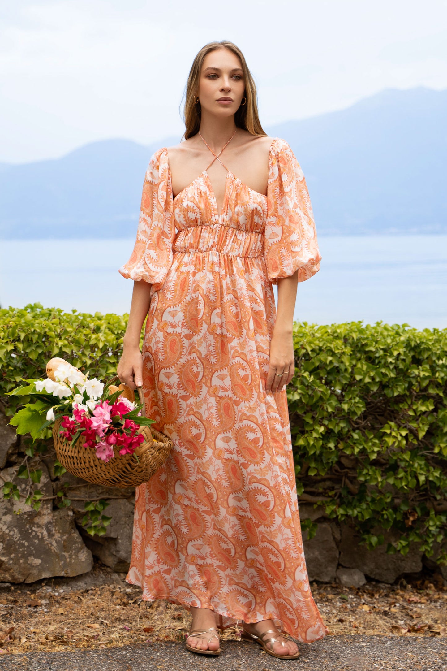 Orange print paisleys maxi dress, with puff sleeves, a-line skirt, shirred bust and crossed straps neckline.