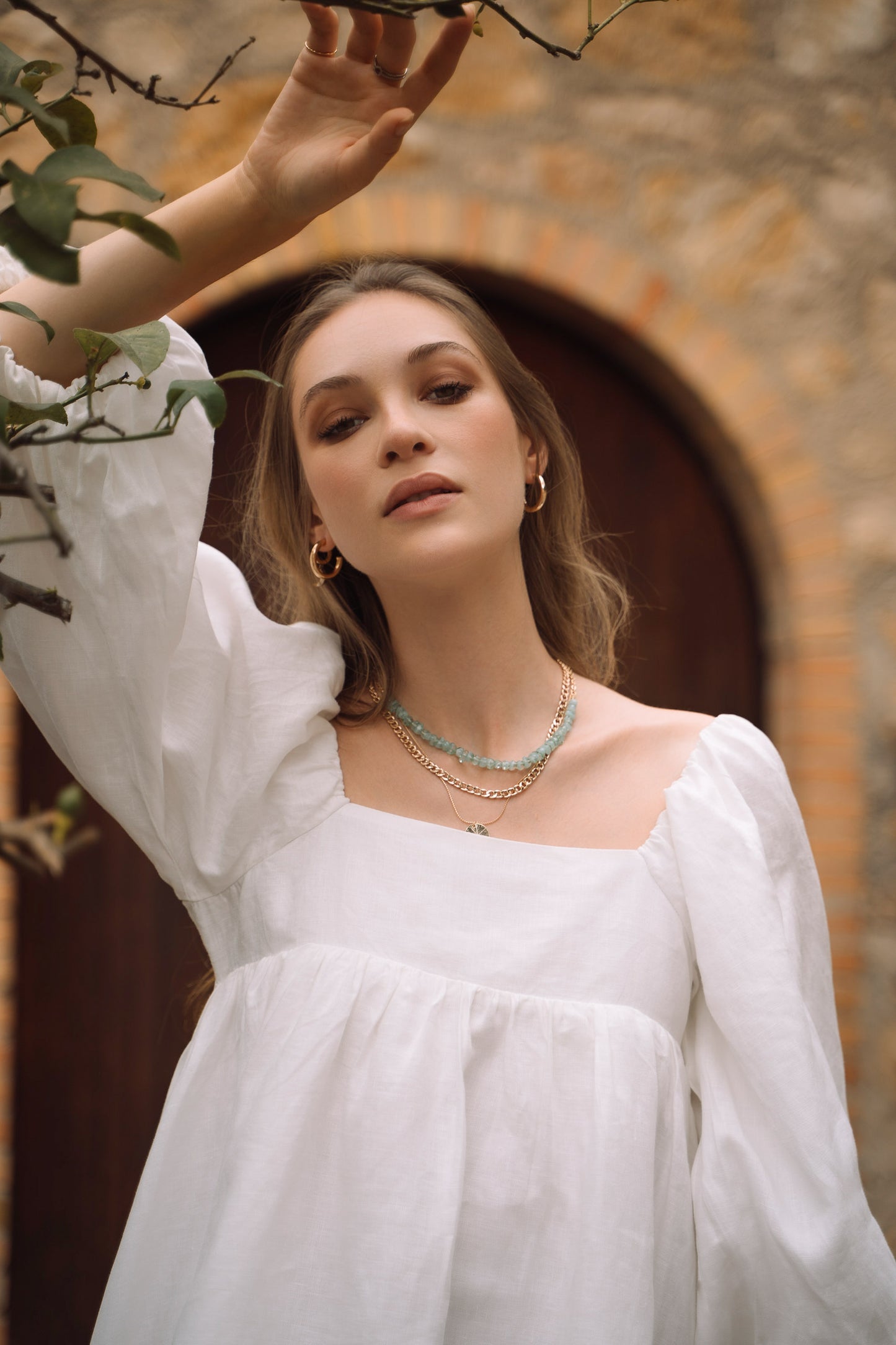 Close-up of white sustainable linen Fiamma Studio mini dress, with puff sleeves and voluminous skirt.