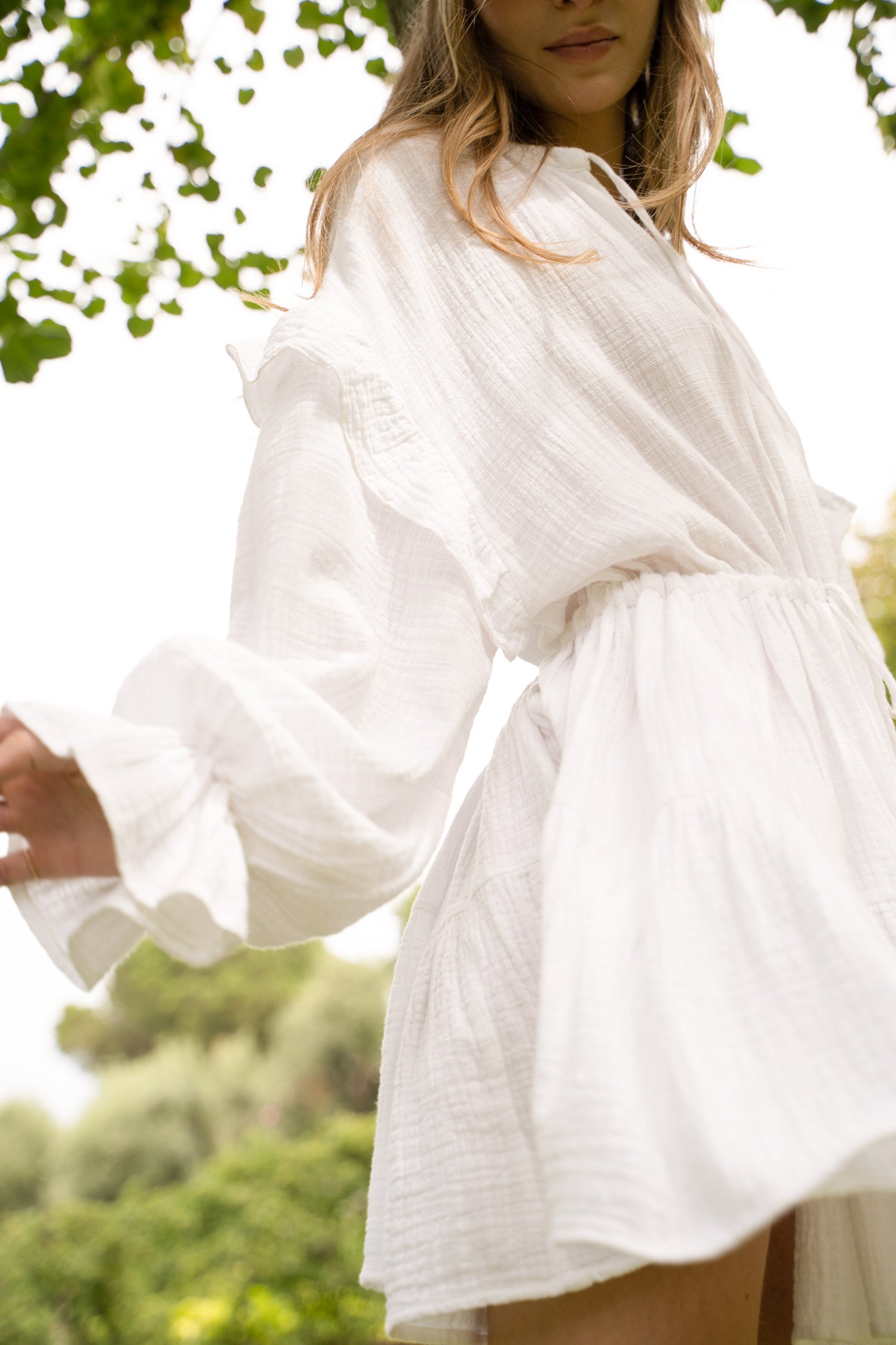 White cotton dress with ruffled sleeves and waist ties.