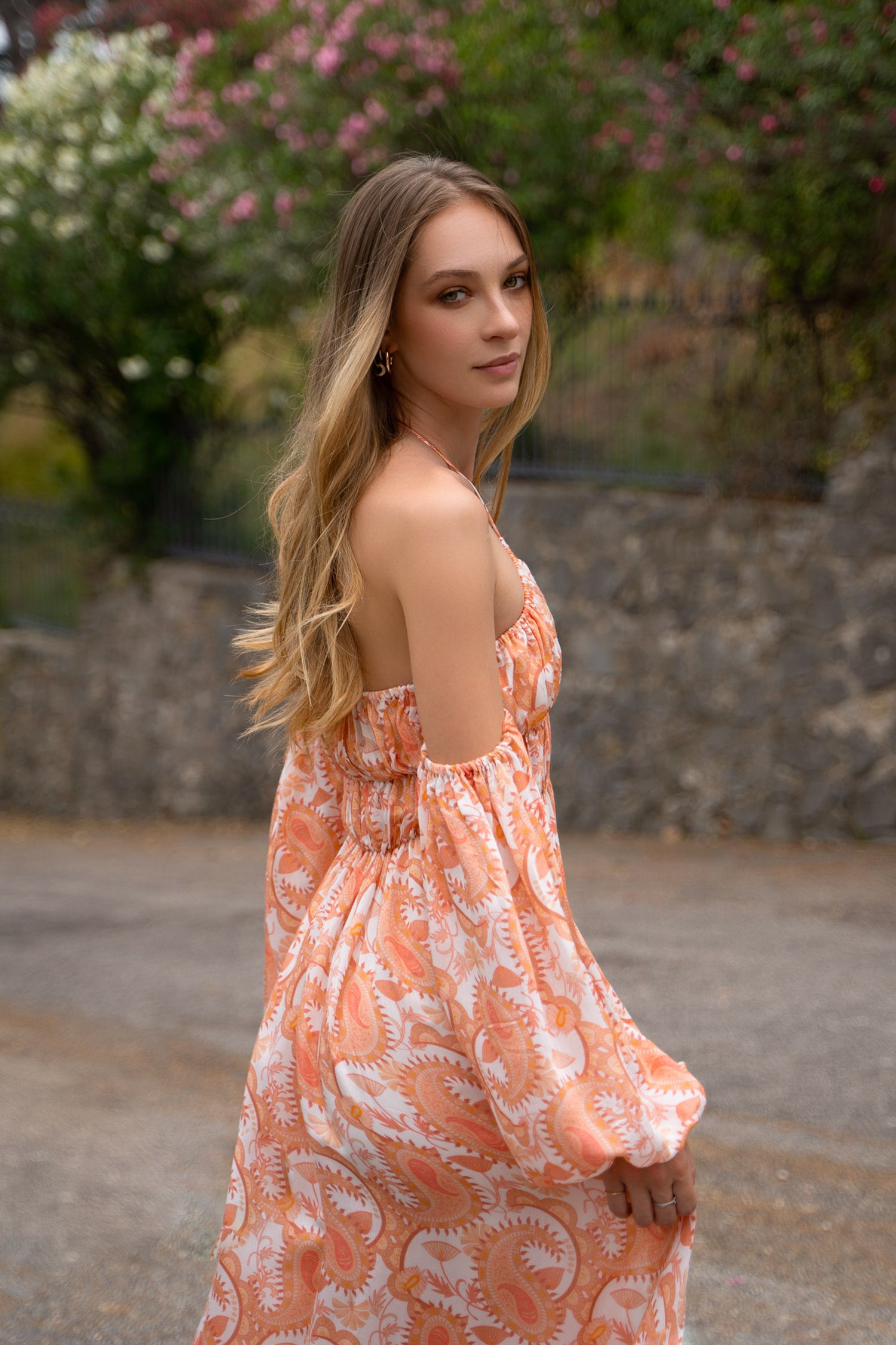 Back of orange floral print maxi Fiamma Studio dress, crafted in bemberg cupro sustainable fabric, with puff sleeves, a-line skirt and shirred bust.