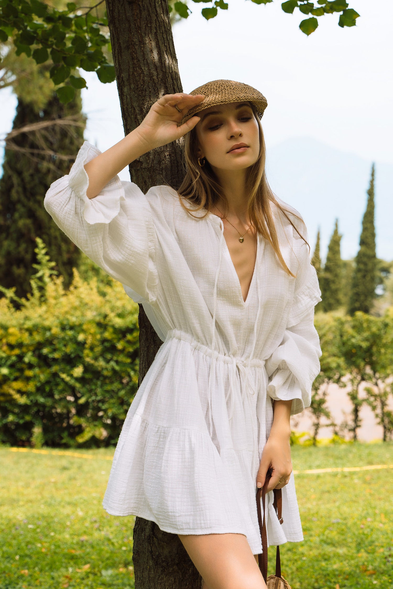 A white summer dress with long puff sleeves and tiered skirt.